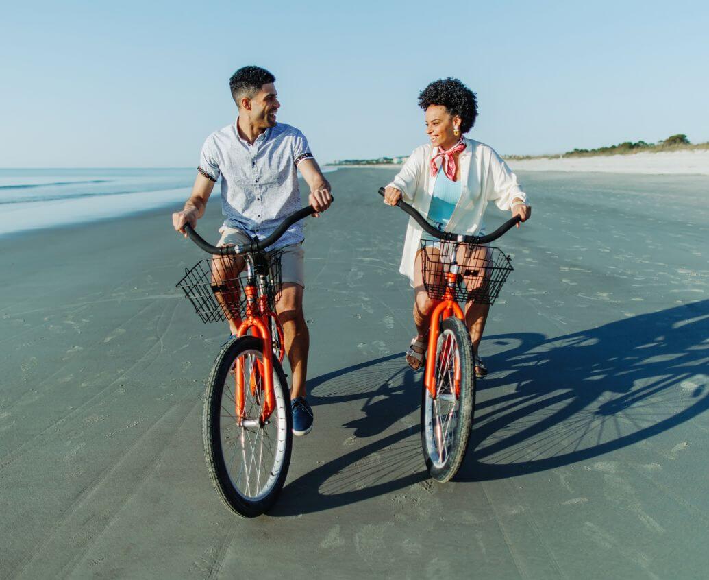 Couple riding bikes on the beach
